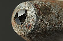 The extreme hardness of diamond in certain orientations makes it useful in materials science, as in this pyramidal diamond embedded in the working surface of a Vickers hardness tester. Vickers anvil diamons.jpg