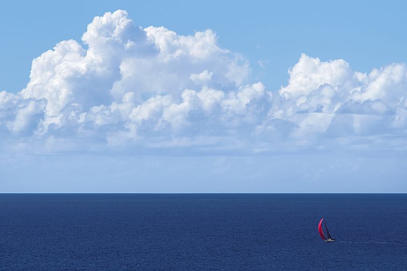 File:Yacht with red spinnaker at full sail on blue ocean with clouds.jpg