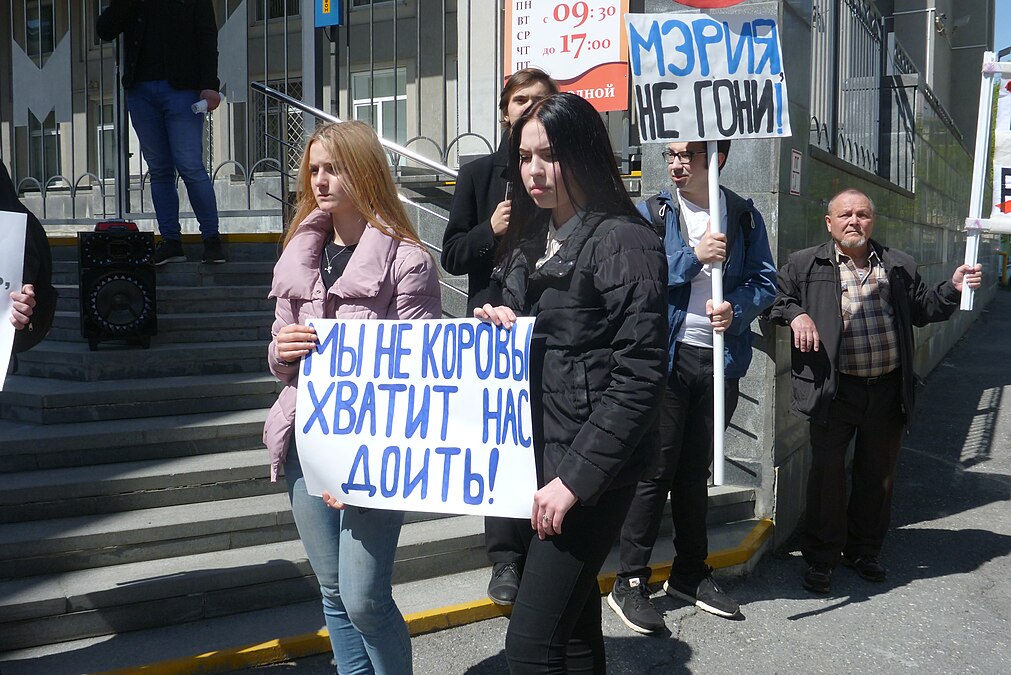 Девушки с плакатами против повышения платы за проезд