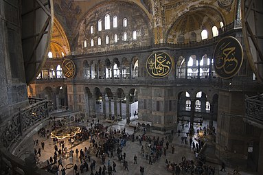Interior of the domed 6th-century Hagia Sophia, with a wide triforium gallery beneath the rows of clerestory and upper dome windows.