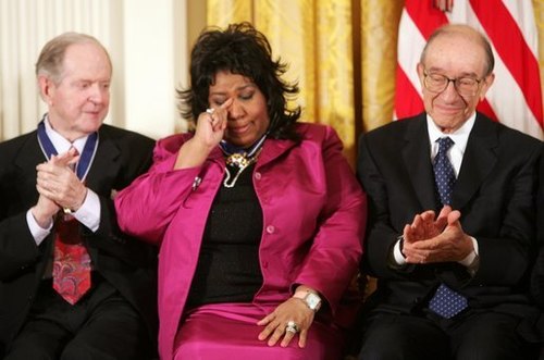 Franklin wipes a tear after being given the Presidential Medal of Freedom on November 9, 2005, at the White House. She is seated between fellow recipients Robert Conquest (left) and Alan Greenspan