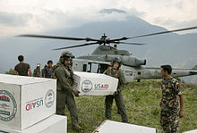 U.S. Marines and Nepalese soldiers unloading tarpaulins for temporary shelter Bringing shelter.jpg