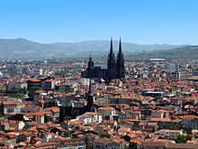 Vue d'une ville dominée par une cathédrale en pierre noire.
