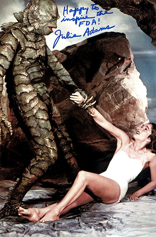 Autographed Julie Adams still, featuring the Creature menacing Kay