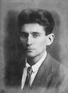 Black-and-white photograph of Kafka as a young man with dark hair in a formal suit