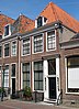 Huis met gevel met rechte kroonlijst, dakkapel. Versierde deurpartij met zijlichten; stoephek