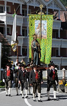 I scizri porta la statua dl Cuer de Gejù de Ludwig Moroder pra la pruzescion dl Sacro Cuer a Urtijëi.