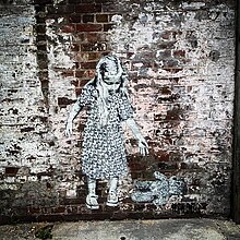 A mural by Hendog of a girl that has dropped a teddy bear on the floor.