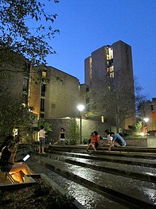 Students sitting near water feature, installed in 2010. MorseCollegeNighttime.jpg