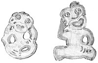 Two greenstone figures of tiki shape. The right figure has both arms raised to the head; the left one has only the right arm raised to the head. Both are apparently very old.