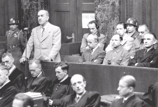 Oswald Pohl, former Chief of the SS Main Economic and Administrative Dept, standing, is indicted on war crimes charges in connection with the operatio