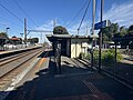 Southbound view of the station building on Platform 2 with fencing around the Myki readers, August 2024