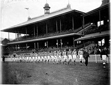 Canberra representative team making its national carnival debut parading the SCG at the 1933 Sydney Carnival. SLNSW 10145 The last player from the Queensland team is followed by the Canberra team marching on in the opening ceremony on the AllStates Australian Football Carnival at the SCG 5 August 1933.jpg