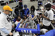 US Navy 100305-N-7676W-182 Cmdr. Jim Grove, from the Office of Naval Research Navy Reserve Program 38, left, helps tudents from McKinley Technology High School make adjustments to their robot.jpg