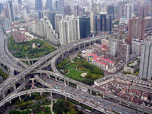 A multi-level stack interchange, buildings, houses, and park in Shanghai, China