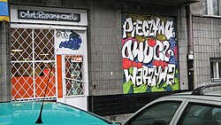 Legal advertising graffiti on grocer's shop window in Warsaw, Poland Warszawa Stary Mokotow graffiti on shop window.jpg