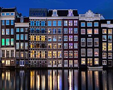 Water reflection of canal houses at blue hour in Damrak Amsterdam the Netherlands