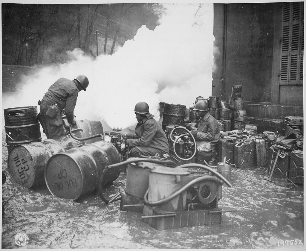 1024px-%22Soldiers_of_the_161st_Chemical_Smoke_Generating_Company%2C_U.S._Third_Army%2C_move_a_barrel_of_oil_in_preparation_to_refill_-_NARA_-_531229.jpg