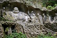Budai as Maitreya at the Feilai Feng grottoes, depicted with disciples.