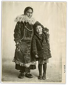 photo noir et blanc d'une femme inuit en tenue traditionnelle serrant près d'elle un jeune garçon