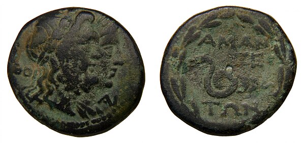 A bronze coin bearing with the heads of Zeus and Dione on the obverse (left) and the legend ΑΜΑΝΤΩΝ (AMANTON) and a serpent on the reverse (right).