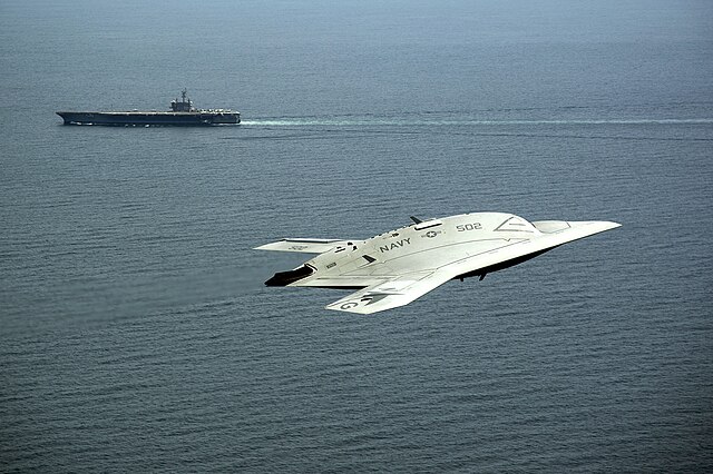 Unmanned X-47B with USS George H.W. Bush (CVN 77) in the background