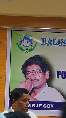 An award has been institute as a tribute to the late journalist Joel D'Souza, represented in the background background; in foreground, Premanand Mahambre An award has been institute as a tribute to the late journalist Joel D'Souza. Seen in photo on background. in foregroundPremanand Mahambre, Dalgado Konkani Akademi, Goa.jpg