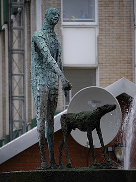 Patung seorang pria berdiri dan anjing