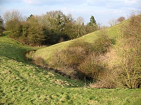 The defensive ditch surrounding the mound Brinklow castle motte.jpg