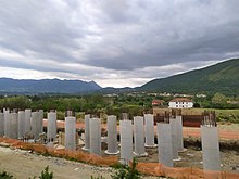 La fotografia raffigura un cantiere con dei pilastri in cemento armato