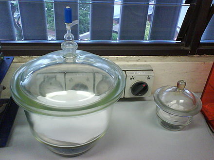 A vacuum desiccator (left - note the stopcock which allows a vacuum to be applied), and a desiccator (right). The blue silica gel in the space below the platform is used as the desiccant.