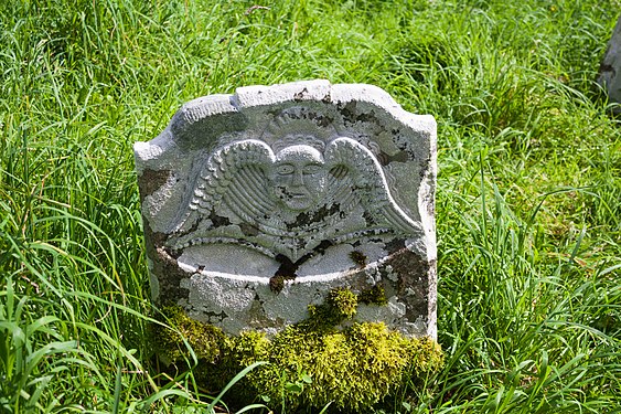 Headstone with winged cherub at the graveyard of Errigal Truagh, County Monaghan, Ireland