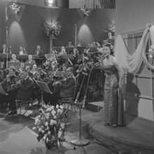 אוגוסטין בעת ביצוע השיר באירוויזיון 1958