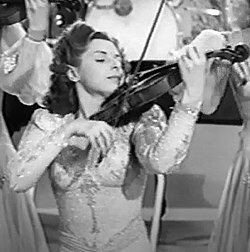 Evelyn Kaye plays with the Hour of Charm Orchestra in this screen capture from Army-Navy Screen Magazine Number 22. Evelyn Kaye from Army-Navy Screen Magazine Number 22.jpg