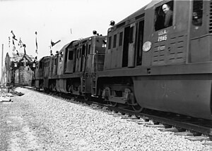 HUA-166384-Afbeelding van de passage van enkele van het Amerikaanse leger overgenomen diesel-electrische locomotieven serie 600 bij de heropening van de van oorlogsschade herstelde spoorbrug over het Hollands Diep bij Moerdijk.jpg