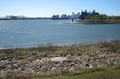 Mississippi River entrance of the Industrial Canal; the Canal runs to the right. View from the levee in the Lower 9th Ward. In center right background, skyscrapers of New Orleans Central Business District are visible across the Mississippi. Distance at left is Crescent City Connection pair of bridges across the river.