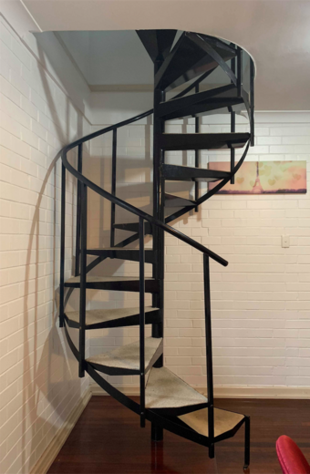 Industrial spiral staircase winding around a central newel