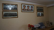 Portraits of Kim Il Sung, Kim Jong Il, and Kim Jong Suk in a private home Kim Il Sung University professorial housing complex (14142429880).jpg