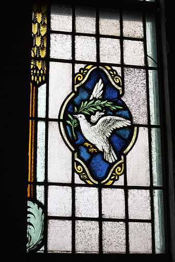 White dove with olive branch, stained glass window in the Denis and Saint Sebastian church in Kruft, Germany