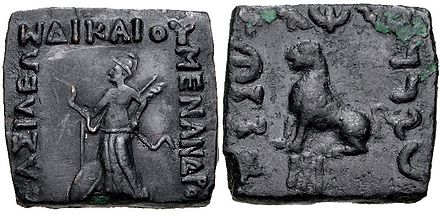 Menander II with Nike making a blessing gesture and seated lion.