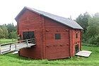 Three-story, octagonal, log threshing barn with a bridge to the second floor in Nätra, Sweden