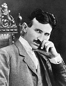 Photograph of Nikola Tesla, a slender, mustachioed man with a thin face and pointed chin.