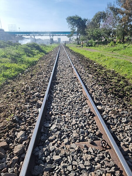 File:Rails of Time- Tracing the historic Nairobi-Nanyuki railway, a journey etched with tales from 1930. Rediscover the impact at Buruburu substation, where history meets the present..jpg
