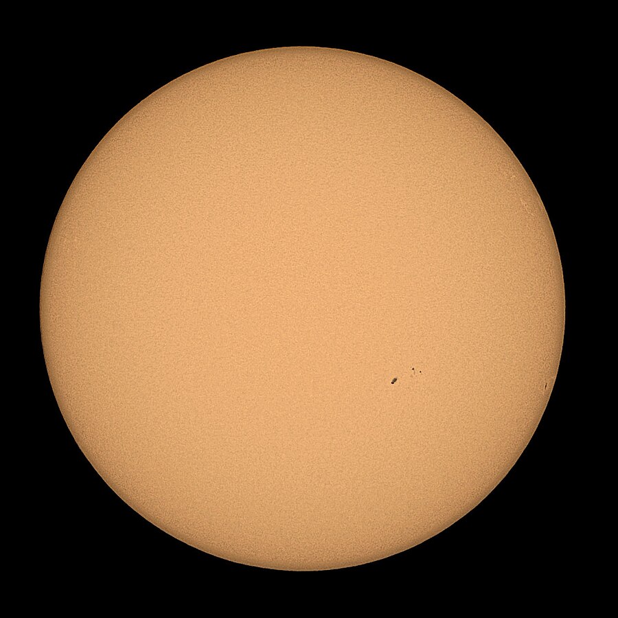 Aufnahme der Sonnenscheibe mit einigen kleinen Sonnenflecken mit einem Neutraldichtefilter mit einem Promille Transmission bei einer Blendenzahl 8, einem Belichtungsindex von ISO 200 und einer Belichtungszeit von 1/32000 Sekunde (der Belichtungswert der Sonnenscheibe betrug 30 EV).