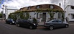 Single storey semi-detached vernacular building; half hipped thatched fanlight to Idoville and glazed Victorian door to Durban House; raised stoep with a low plastered wall and plastered brick columns supporting a timber pergola; Original outbuildings Type of site: House Current use: House. Wynberg, Cape Town - WLM 2013 -13.JPG