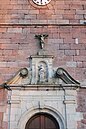 Statue de saint Étienne et crucifix sur la partie supérieure du portail de l'église.