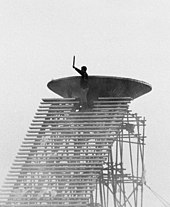 Alain Calmat, brandissant la torche, s'apprête à allumer la vasque de la flamme olympique, lors de la cérémonie d'ouverture.