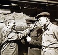 عکس یادگاری سرباز آمریکایی در حال روشن کردن آتش سیگار برای دو سرباز روسی، در جلوی یک لوکوموتیو ساخت آلمان که برای استفاده در خطوط راه‌آهن روسیه فرستاده می‌شود.