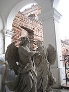 Statues of angels in a heraldic setting, with ruins in the background