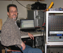 Hughes in 2013 with audio test and analysis equipment Charlie Hughes with audio test and measurement equipment.png